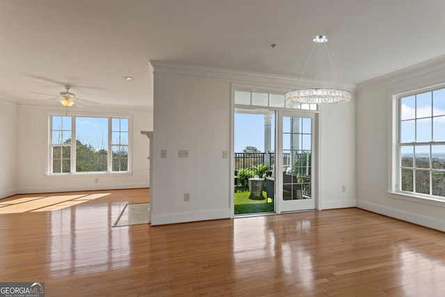 unfurnished dining area with crown molding, baseboards, healthy amount of natural light, and wood finished floors