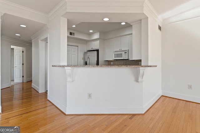 kitchen with stainless steel refrigerator with ice dispenser, white microwave, baseboards, light wood-style floors, and recessed lighting