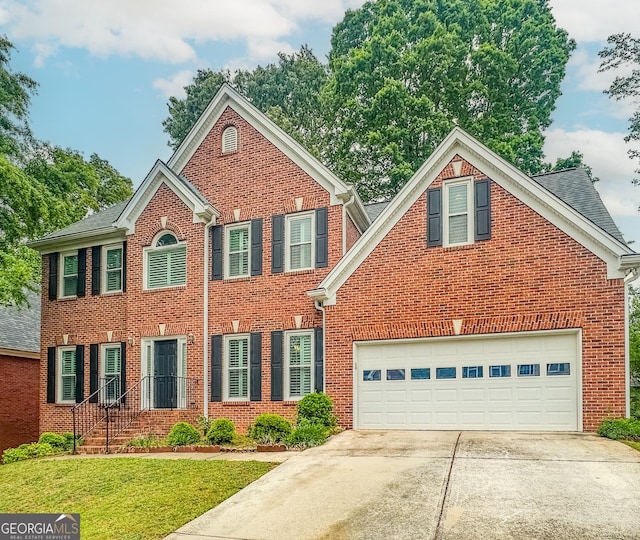 1485 Oglethorpe Run Ln, Suwanee, GA 30024 - colonial-style house with a garage, brick siding, a front lawn, and concrete driveway