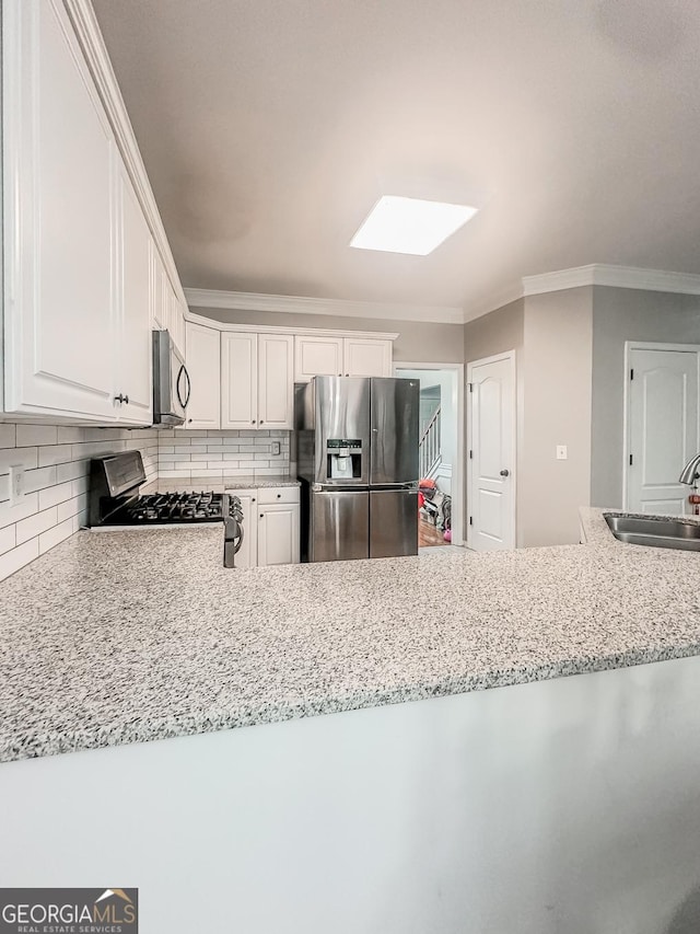1485 Oglethorpe Run Ln, Suwanee, GA 30024 - kitchen with a skylight, appliances with stainless steel finishes, ornamental molding, a sink, and white cabinetry