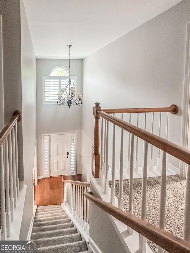 1485 Oglethorpe Run Ln, Suwanee, GA 30024 - stairs with a chandelier, baseboards, wood finished floors, and a high ceiling