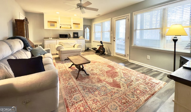 living area with baseboards, recessed lighting, wood finished floors, and ceiling fan