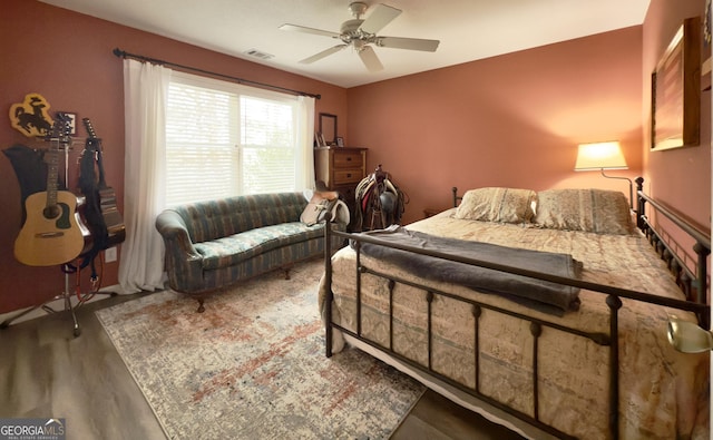 bedroom with wood finished floors, visible vents, and a ceiling fan