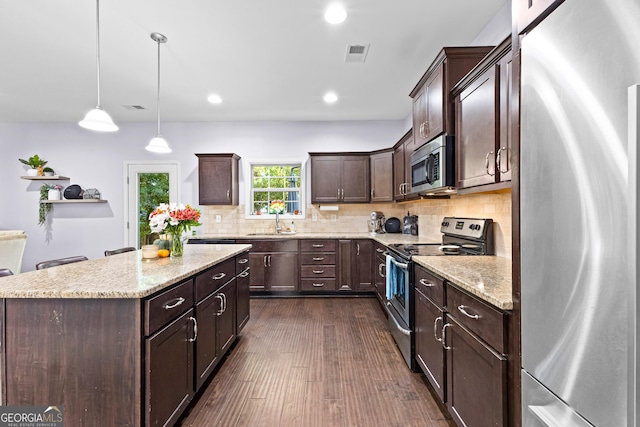 171 Cliffhaven Cir, Newnan, GA 30263 - kitchen with dark brown cabinetry, visible vents, a center island, a sink, and stainless steel appliances