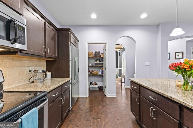 171 Cliffhaven Cir, Newnan, GA 30263 - kitchen with dark brown cabinets, tasteful backsplash, light stone counters, arched walkways, and stainless steel appliances