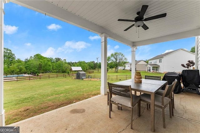 837 Porches Way, Dacula, GA 30019 - fenced backyard featuring a patio, outdoor dining area, a storage unit, and ceiling fan