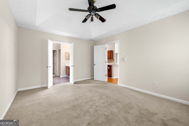 1452 Evanston Ln, Marietta, GA 30062 - unfurnished bedroom featuring a raised ceiling, ceiling fan, baseboards, carpet floors, and ensuite bath