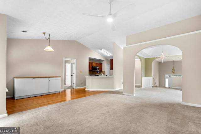 1452 Evanston Ln, Marietta, GA 30062 - unfurnished living room with light colored carpet, ceiling fan, visible vents, arched walkways, and vaulted ceiling
