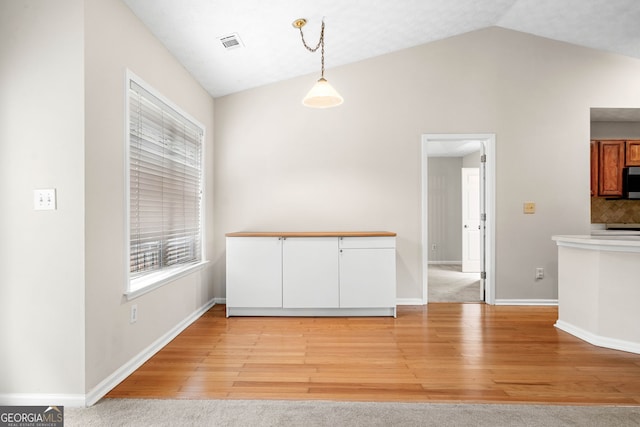 1452 Evanston Ln, Marietta, GA 30062 - unfurnished dining area featuring baseboards, visible vents, light wood-type flooring, and vaulted ceiling