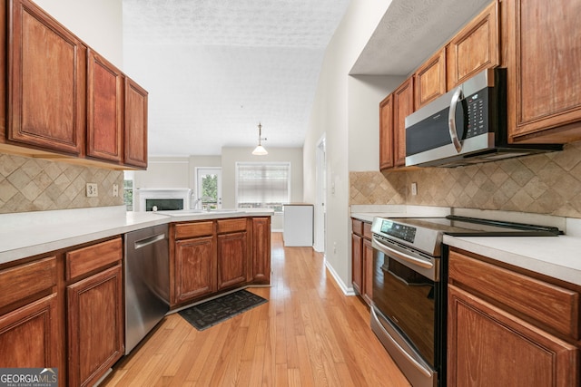 1452 Evanston Ln, Marietta, GA 30062 - kitchen featuring brown cabinets, decorative backsplash, stainless steel appliances, light wood-type flooring, and light countertops