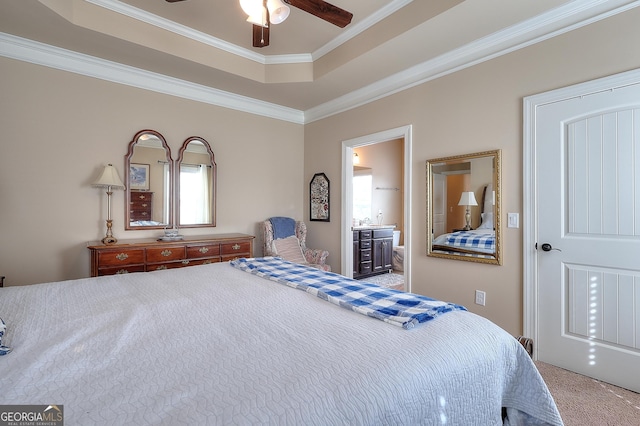 bedroom featuring ensuite bath, a tray ceiling, ornamental molding, and carpet flooring