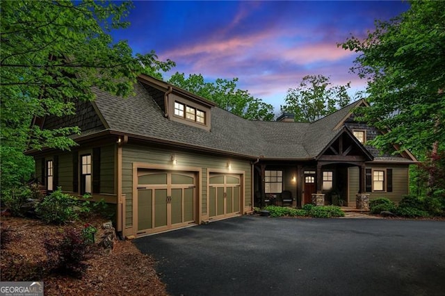 view of front of property with driveway, a shingled roof, and a porch