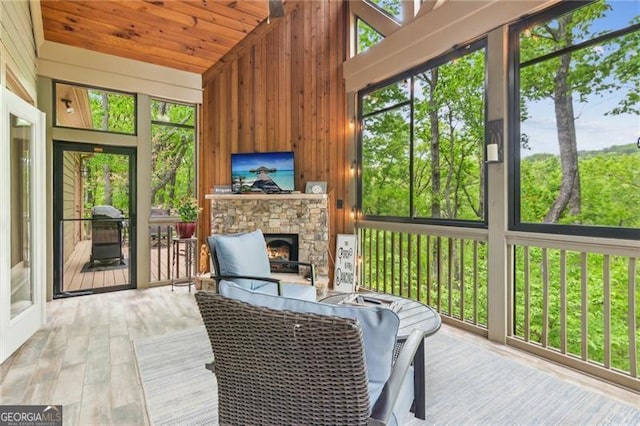 sunroom / solarium featuring a fireplace and lofted ceiling
