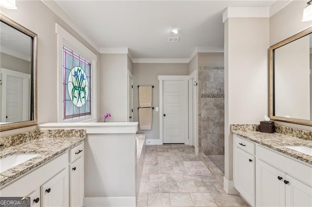bathroom with two vanities, tiled shower, baseboards, and crown molding