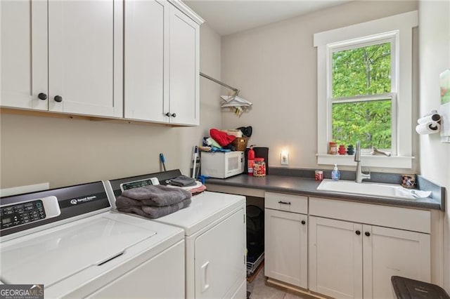 clothes washing area with washing machine and clothes dryer and cabinet space