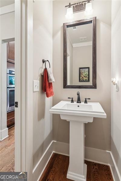 bathroom featuring wood finished floors and baseboards