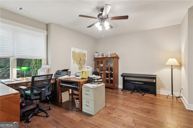 office with wood finished floors, a ceiling fan, and baseboards