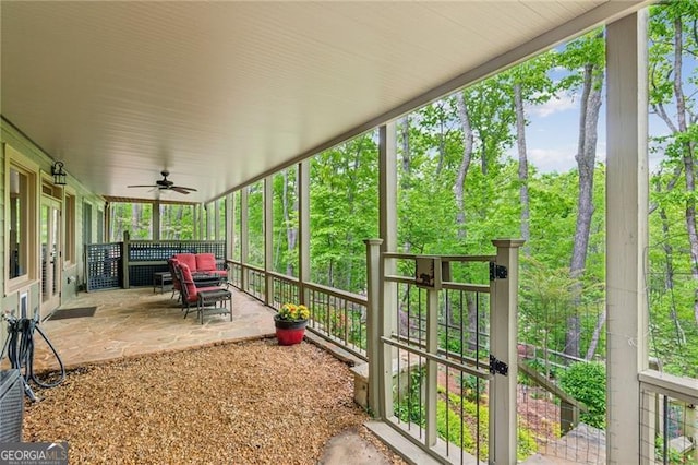 unfurnished sunroom featuring a ceiling fan