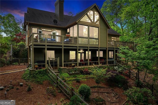 back of house featuring a chimney and a deck