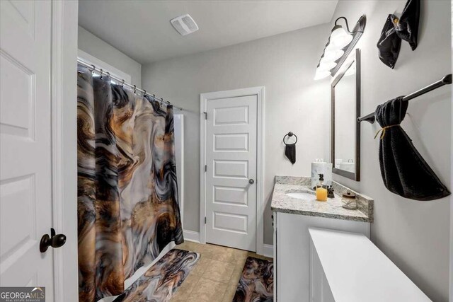 bathroom with tile patterned floors, curtained shower, vanity, baseboards, and visible vents