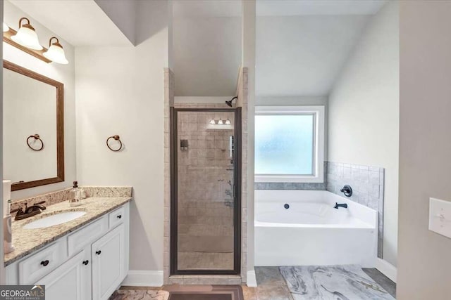 bathroom featuring a garden tub, a stall shower, and vanity