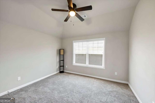 carpeted spare room with baseboards, visible vents, ceiling fan, and lofted ceiling