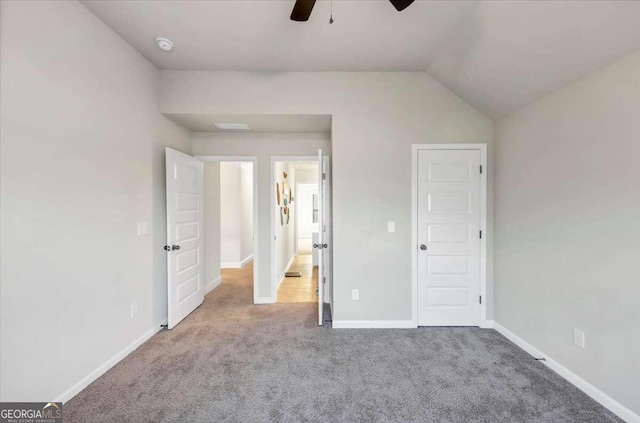 unfurnished bedroom with baseboards, a ceiling fan, carpet flooring, and vaulted ceiling