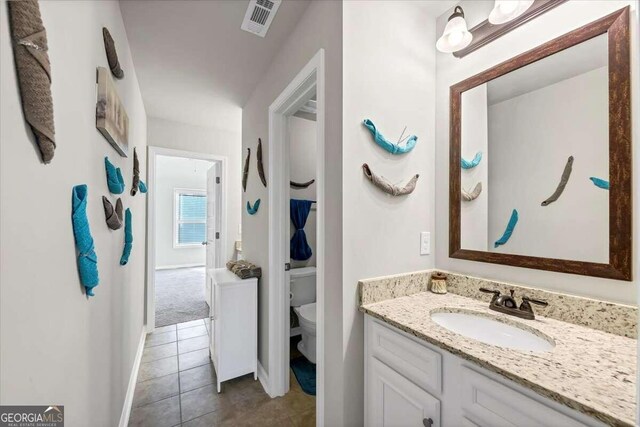 bathroom featuring visible vents, baseboards, toilet, tile patterned floors, and vanity