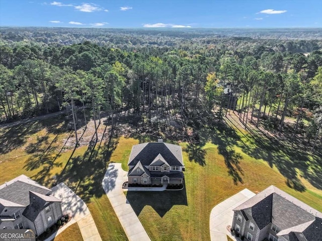 birds eye view of property featuring a forest view