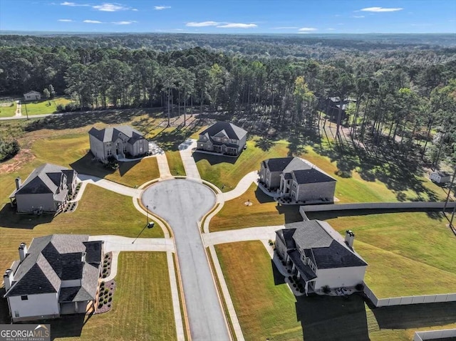 bird's eye view with a wooded view