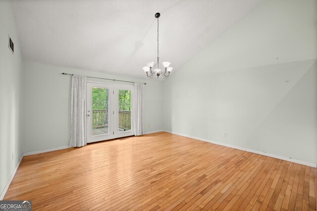 3592 Lakeview Dr, Gainesville, GA 30501 - empty room featuring wood-type flooring, a notable chandelier, visible vents, vaulted ceiling, and baseboards