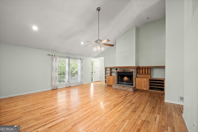 3592 Lakeview Dr, Gainesville, GA 30501 - unfurnished living room with vaulted ceiling, light wood-type flooring, a brick fireplace, visible vents, and a ceiling fan
