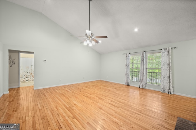 3592 Lakeview Dr, Gainesville, GA 30501 - unfurnished living room with ceiling fan, high vaulted ceiling, light wood-style flooring, and baseboards