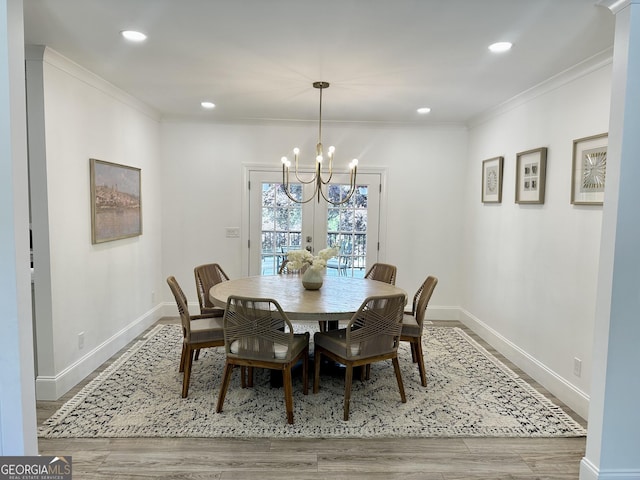 dining area featuring recessed lighting, a notable chandelier, baseboards, ornamental molding, and wood finished floors