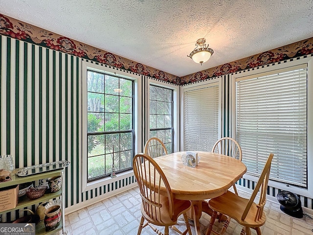 dining room with brick patterned floor, a wealth of natural light, and wallpapered walls