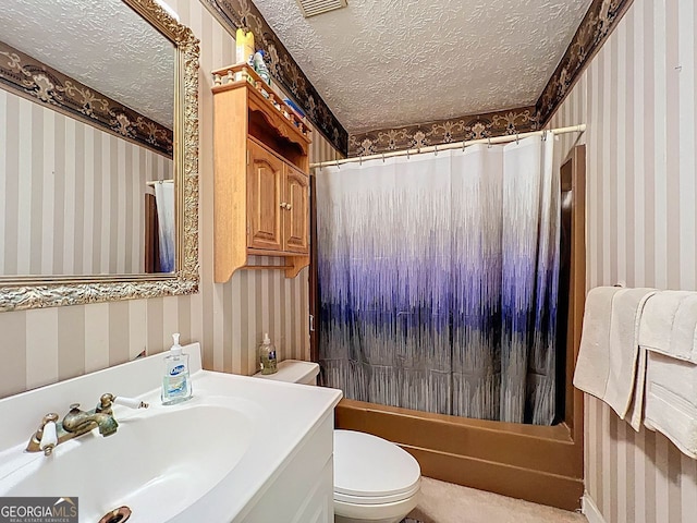 bathroom featuring toilet, wallpapered walls, and a textured ceiling