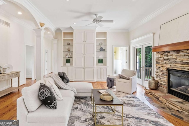 145 Havenbrooke Ct, Fayetteville, GA 30214 - living room with a ceiling fan, visible vents, a stone fireplace, light wood-style flooring, and ornate columns