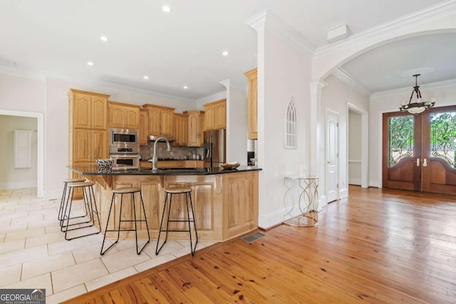 145 Havenbrooke Ct, Fayetteville, GA 30214 - kitchen with stainless steel appliances, visible vents, a peninsula, arched walkways, and french doors