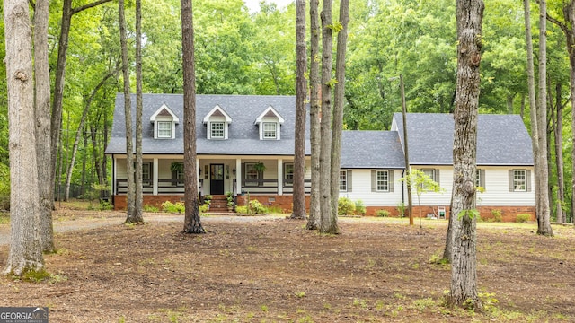 new england style home featuring a porch, crawl space, and roof with shingles