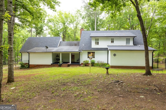 view of front of property with fence, a front lawn, crawl space, a chimney, and covered porch
