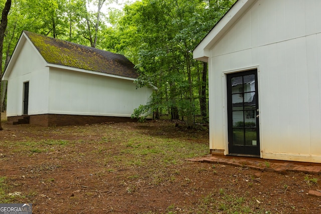 view of side of home featuring an outbuilding