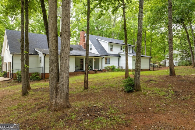 view of front of home with roof with shingles and a chimney