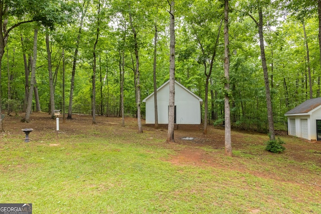 view of yard with an outbuilding and a forest view