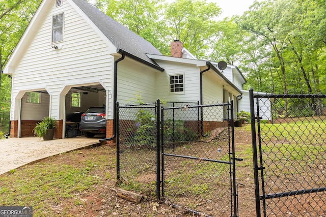 view of side of home featuring fence, a shingled roof, a gate, a chimney, and driveway