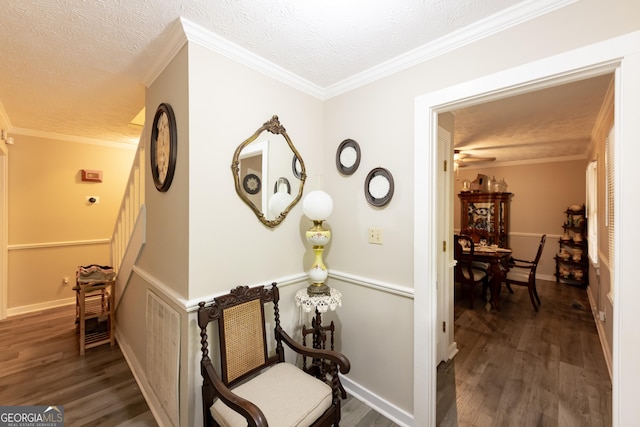 corridor featuring stairway, a textured ceiling, ornamental molding, and wood finished floors