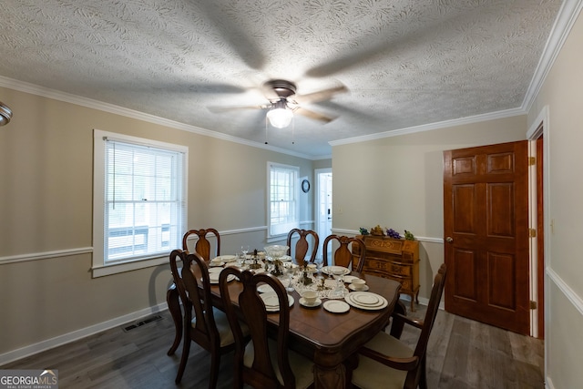dining room featuring crown molding, ceiling fan, dark wood-type flooring, and visible vents