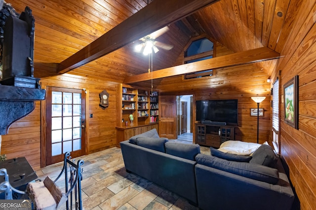 living area with wooden walls, lofted ceiling with beams, wood ceiling, and stone tile flooring