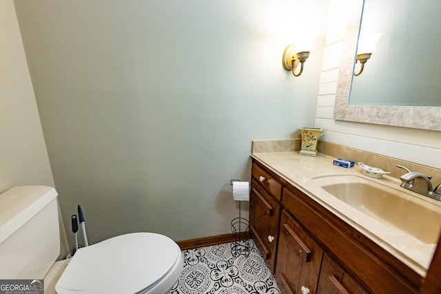 bathroom featuring toilet, tile patterned floors, baseboards, and vanity
