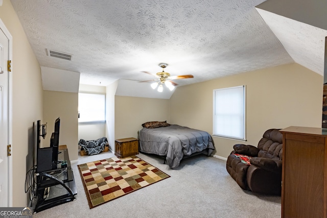 carpeted bedroom featuring visible vents, a ceiling fan, a textured ceiling, and lofted ceiling