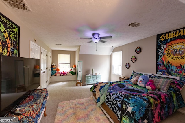 bedroom with carpet floors, a ceiling fan, a textured ceiling, and visible vents